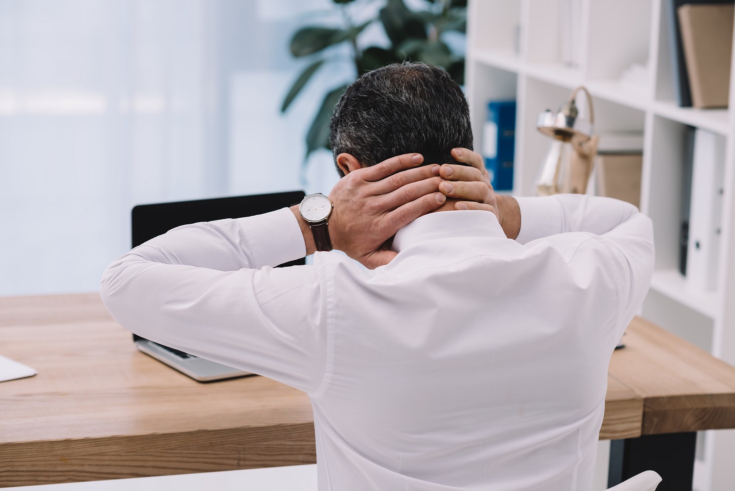 rear view of businessman with neck pain 
