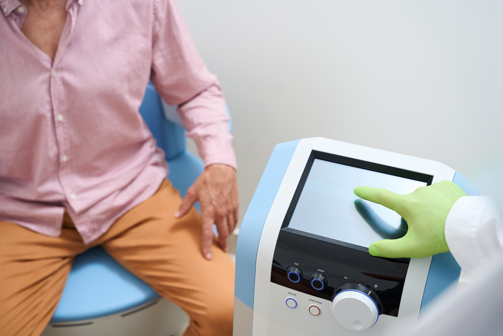 physiotherapist adjusts a device for physiotherapy