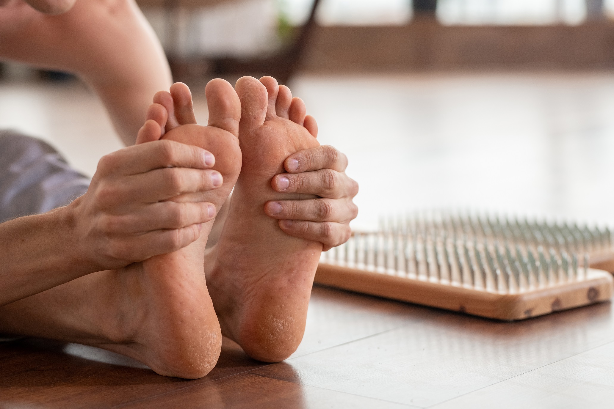 barefoot man sitting on wooden floor