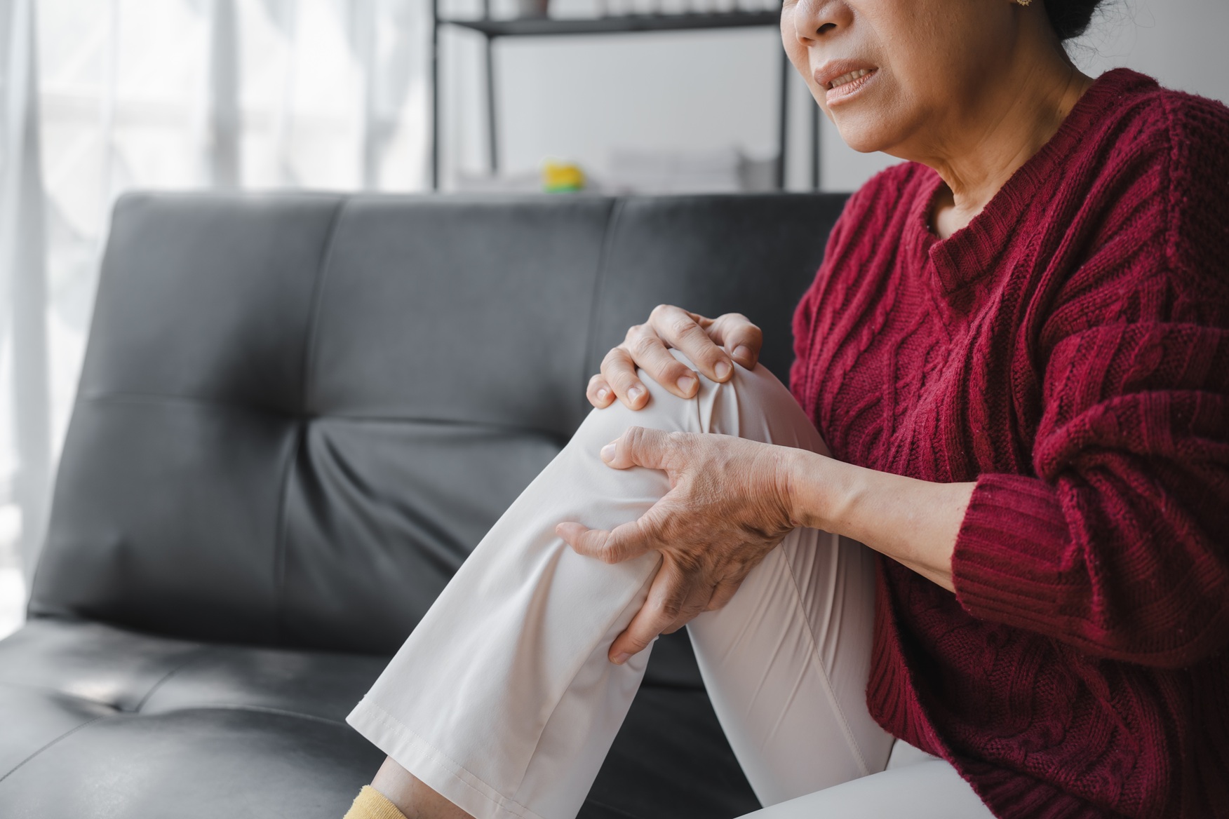 senior woman with knee pain massaging leg 2026