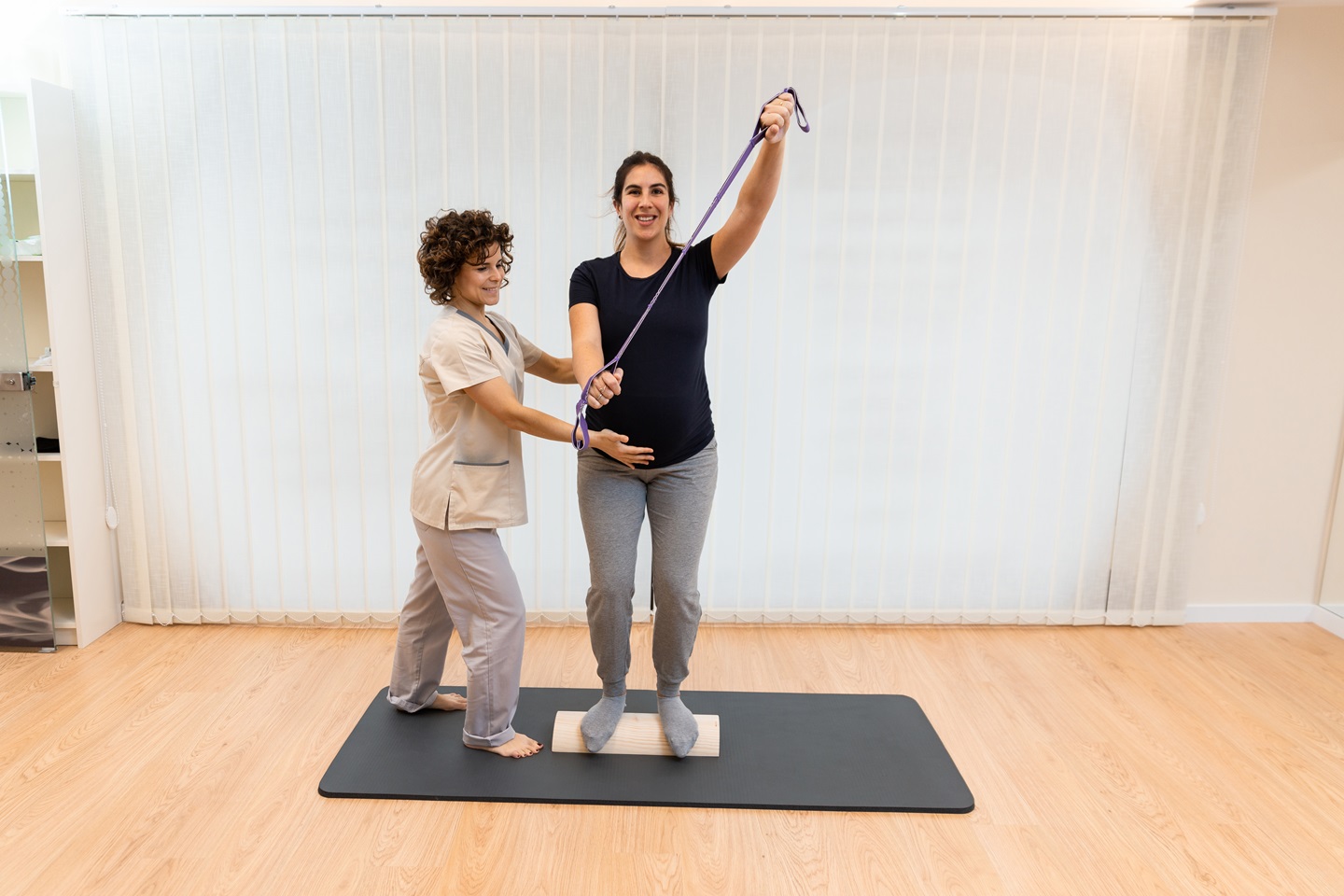 a pregnant woman standing on a proprioceptive trun