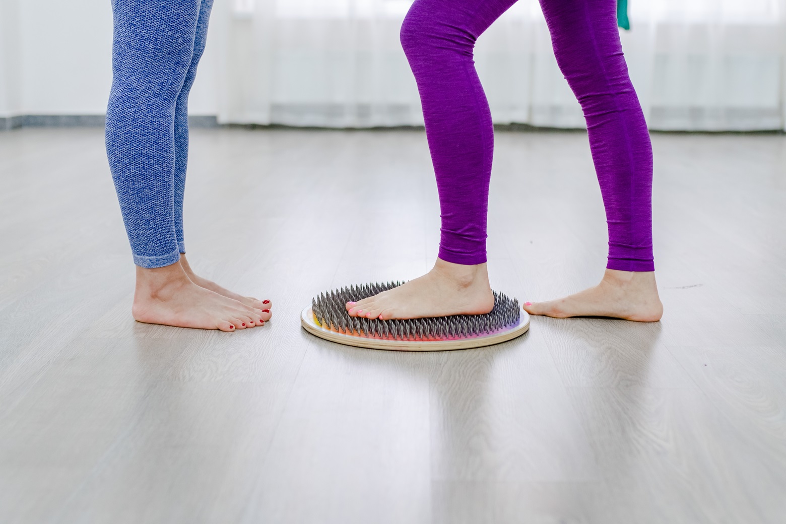 womans feet stands on a board with nails yogi wom