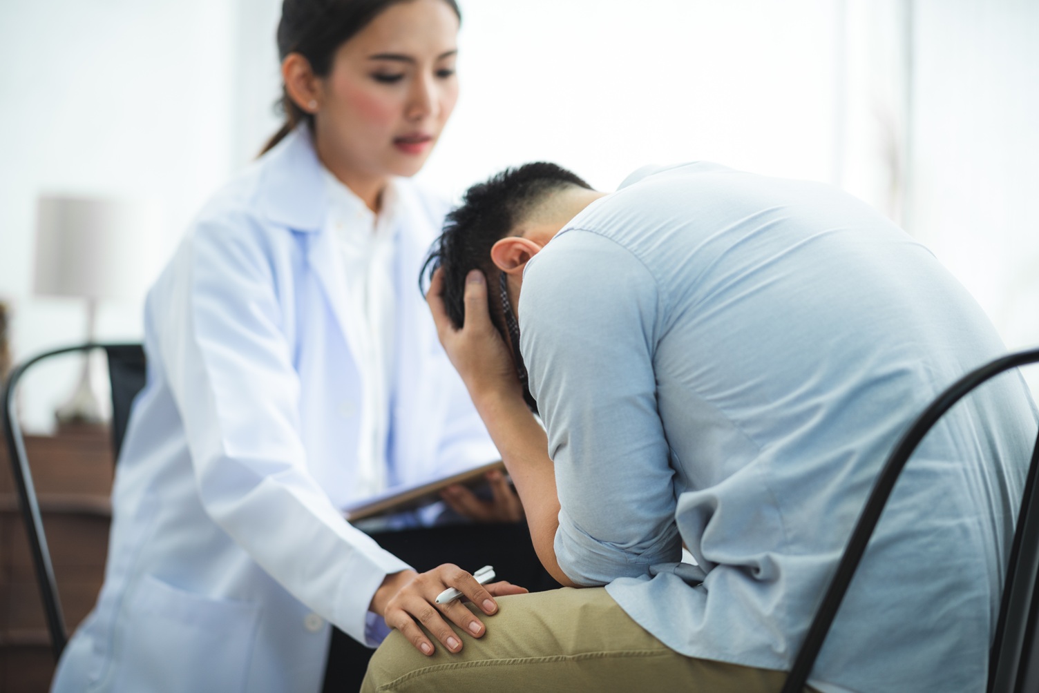 close up of psychologist comforting his depressed 202