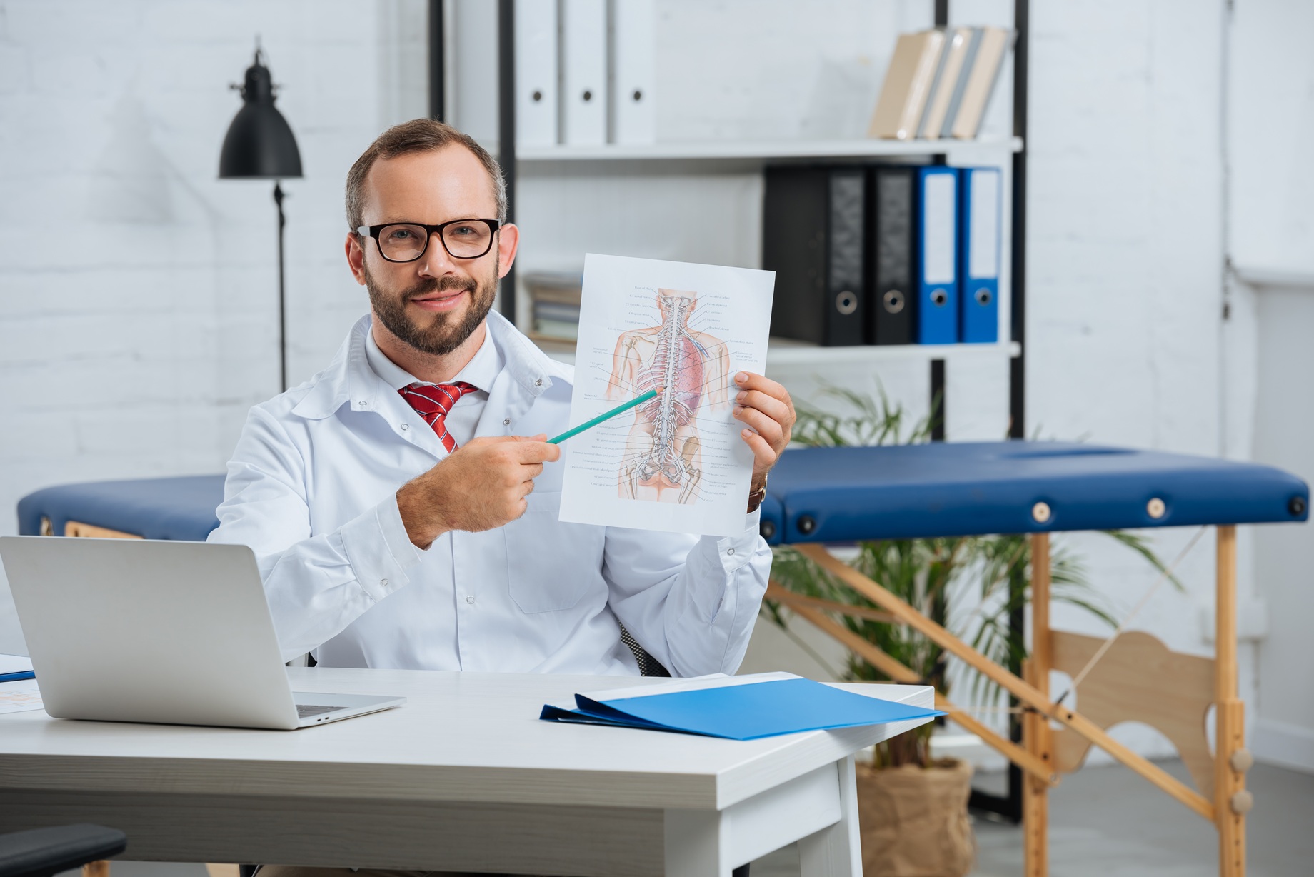 portrait of male chiropractor in white coat and