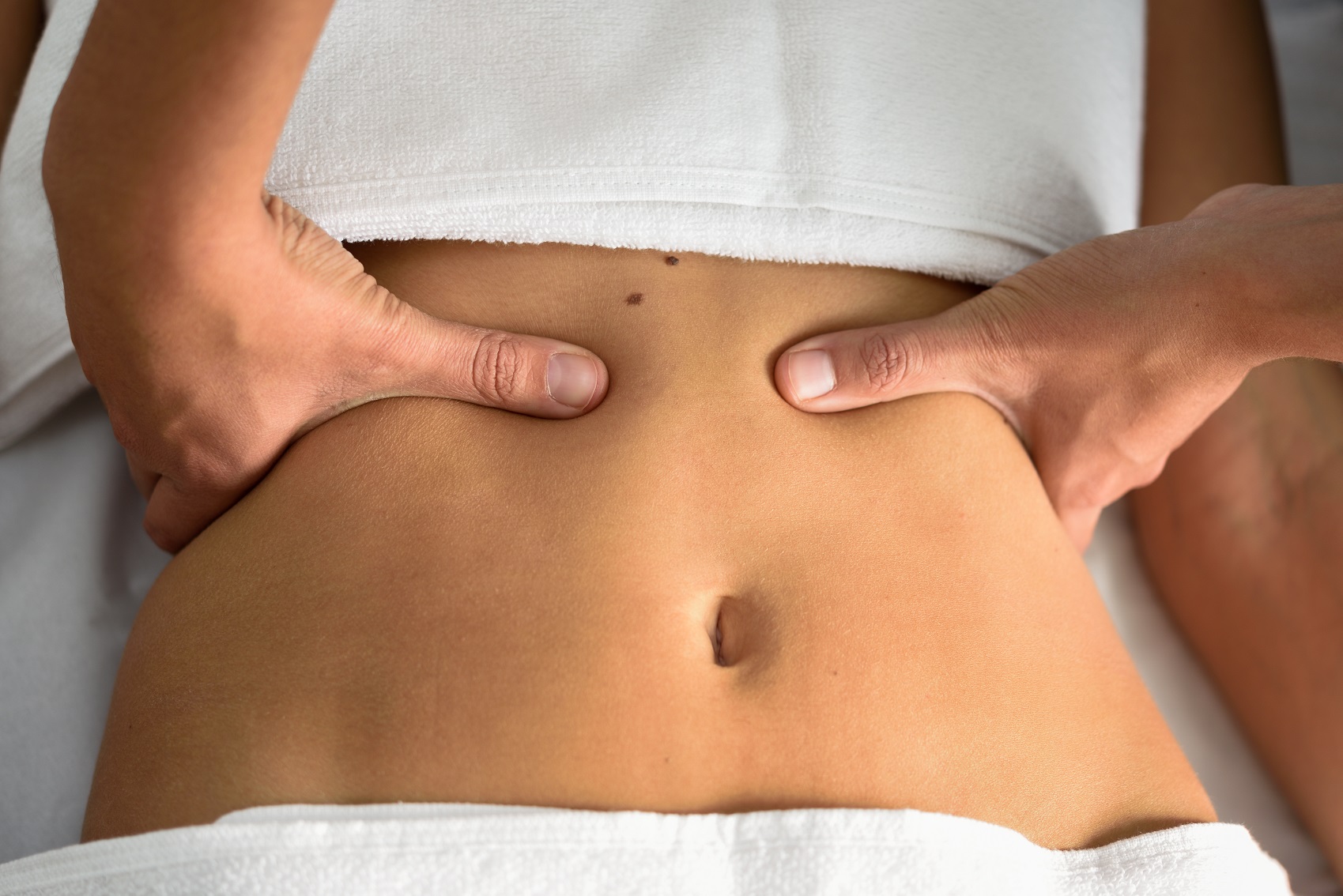 female abdomen therapist applying pressure belly